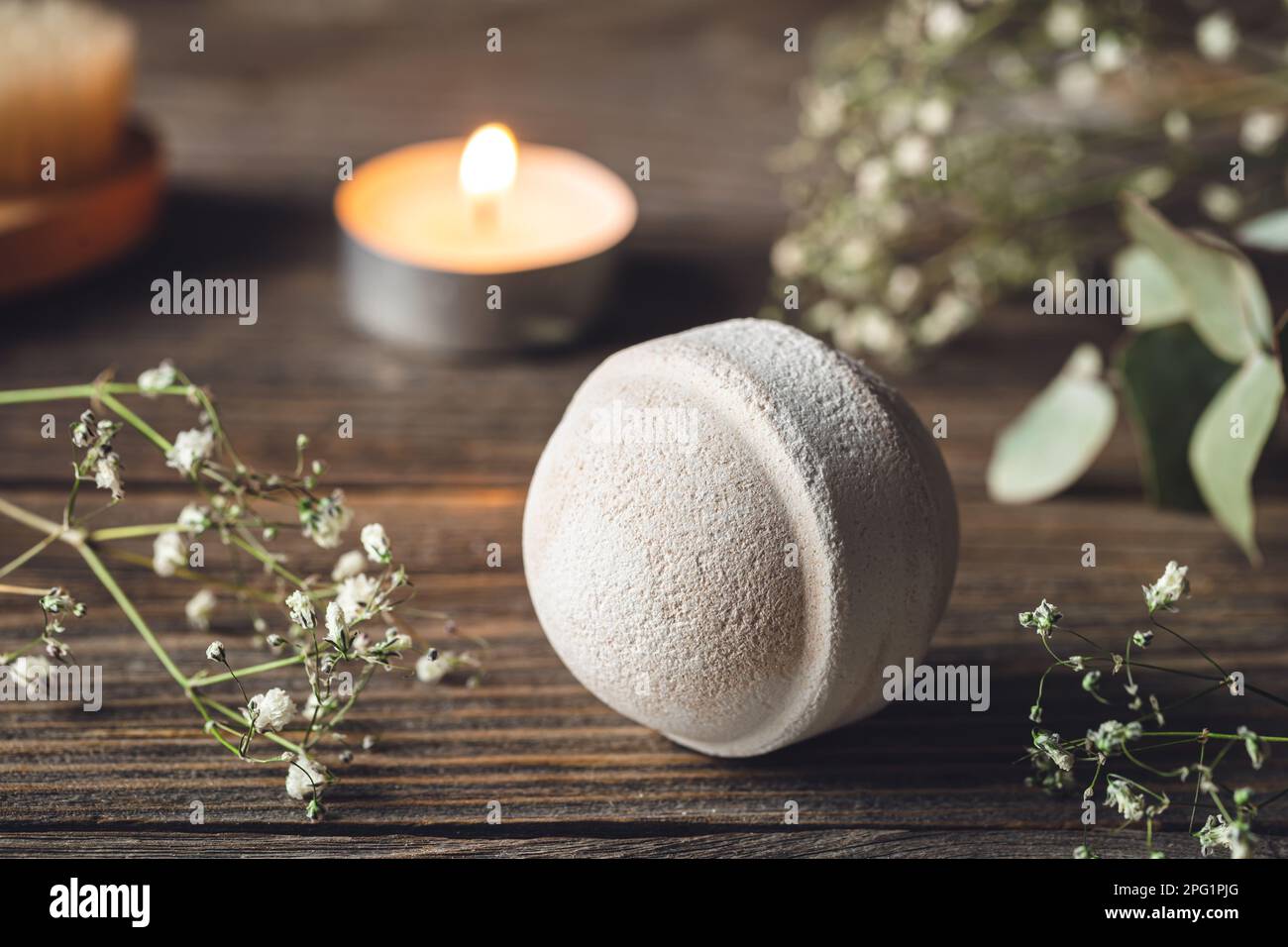 Spa-Komposition mit Badebombe, Kerze und getrockneten Blumen. Stockfoto