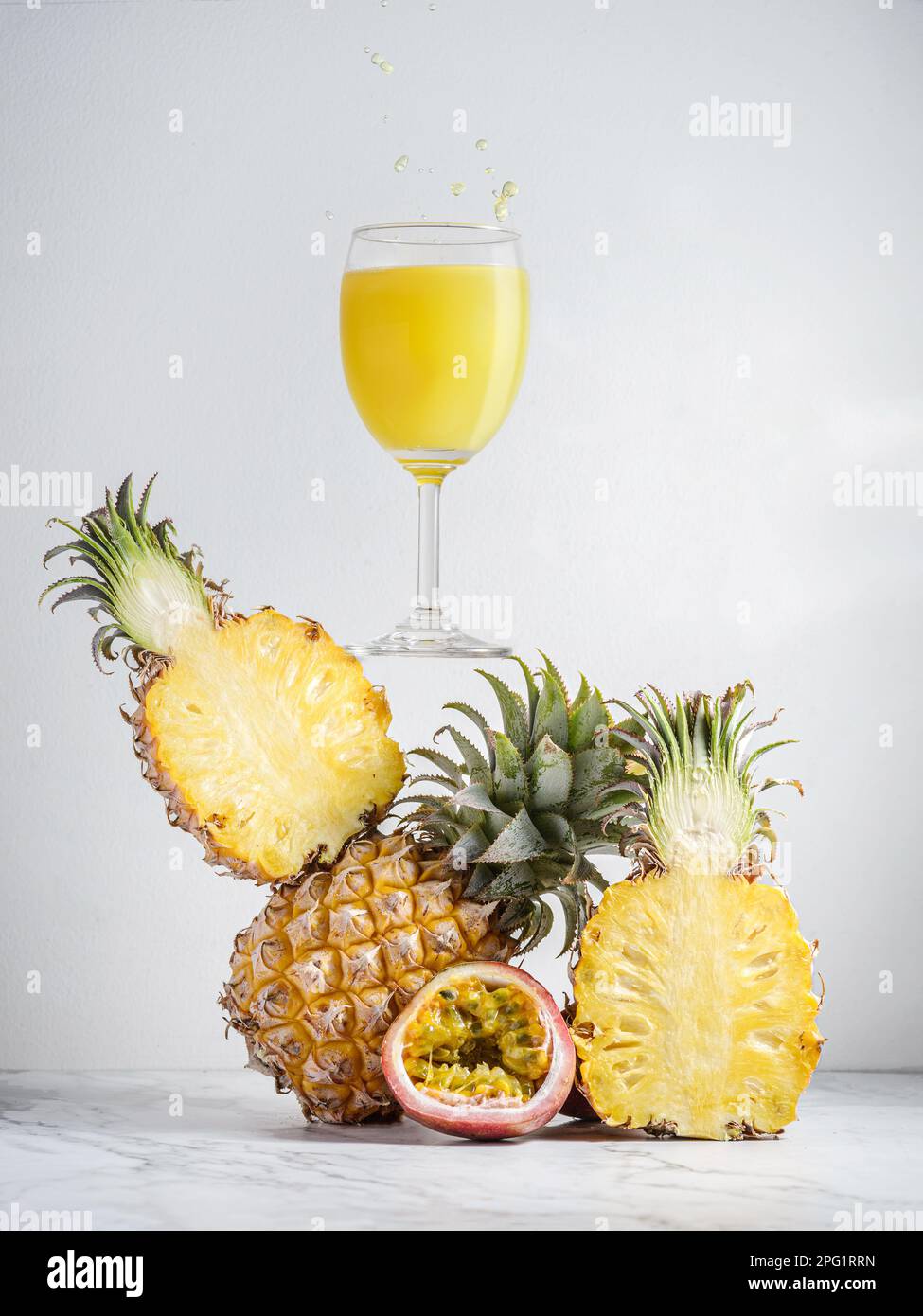 Ananassaft in ausgewogener Zusammensetzung mit Passionsfrucht mit Spritzer. Hochwertiges Foto Stockfoto