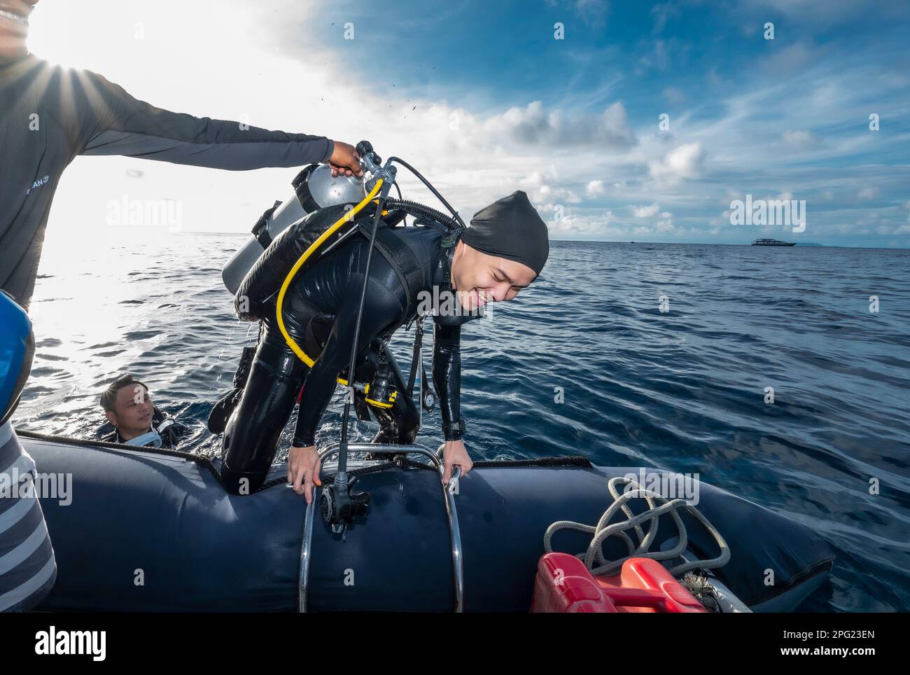 Taucher klettern nach einem Tauchgang im Banda-Meer in ein Schlauchboot Stockfoto