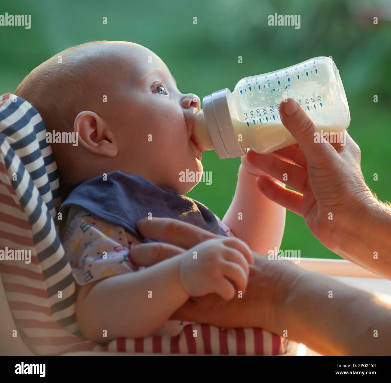 Ein kleines Kind trinkt Milch aus einer Flasche. Stockfoto