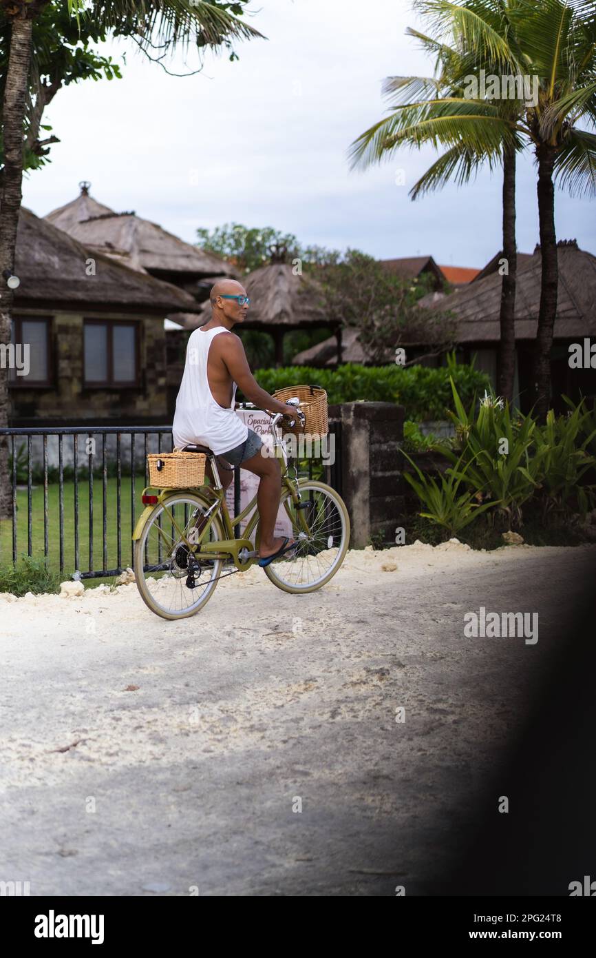Ein Mann fährt mit dem Fahrrad zum Strand, Bali. Stockfoto
