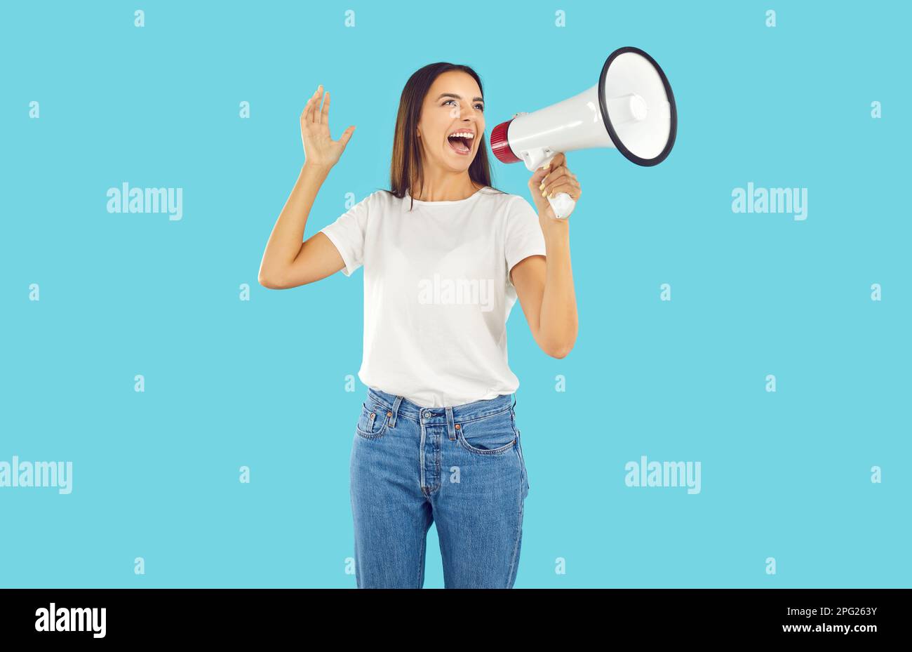 Eine Frau in T-Shirt und Jeans, die durch das Megafon schreit, um unsere Aufmerksamkeit auf etwas zu lenken Stockfoto