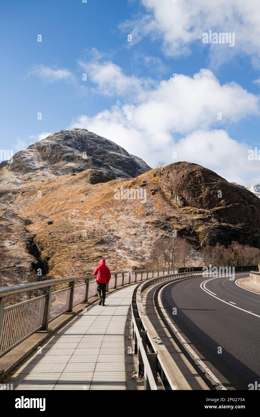 Alleinmann, der auf dem Bürgersteig in schottischen Highlands spaziert Stockfoto