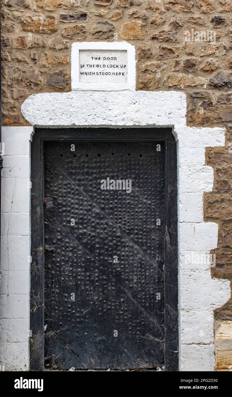Eine schrullige schwarze Tür in der Küstenstadt Lyme Regis in Dorset. Die Worte über der Tür lauteten "die Tür des alten Schlosses, das hier stand". Stockfoto