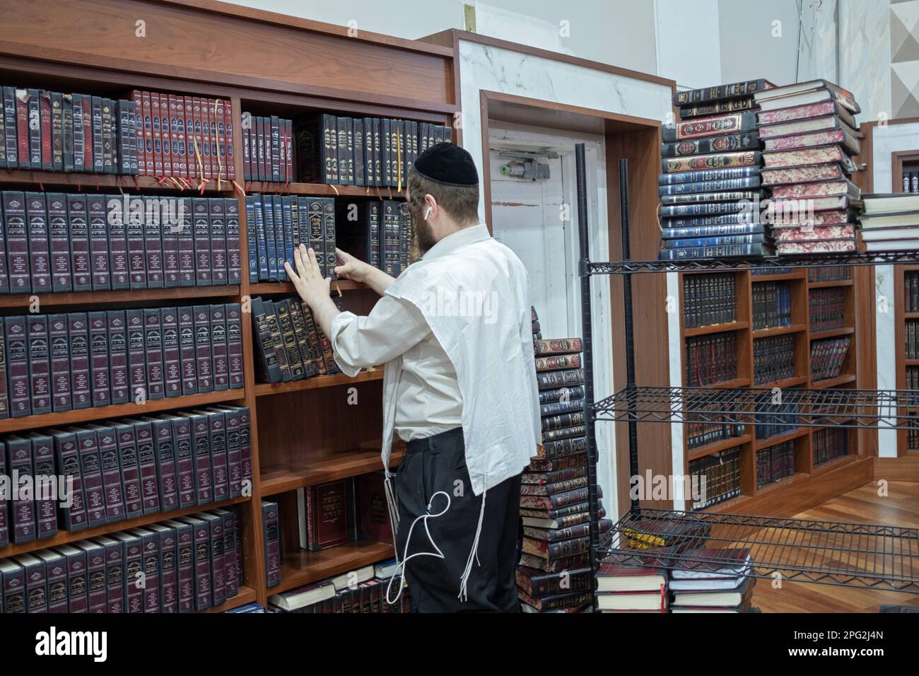 Ein Sexton in einer Synagoge entfernt Volumen von Exodus und fügt Mengen von Leviticus hinzu, damit Gläubige während der Torah-Lesungen den Überblick behalten können. In New York City. Stockfoto