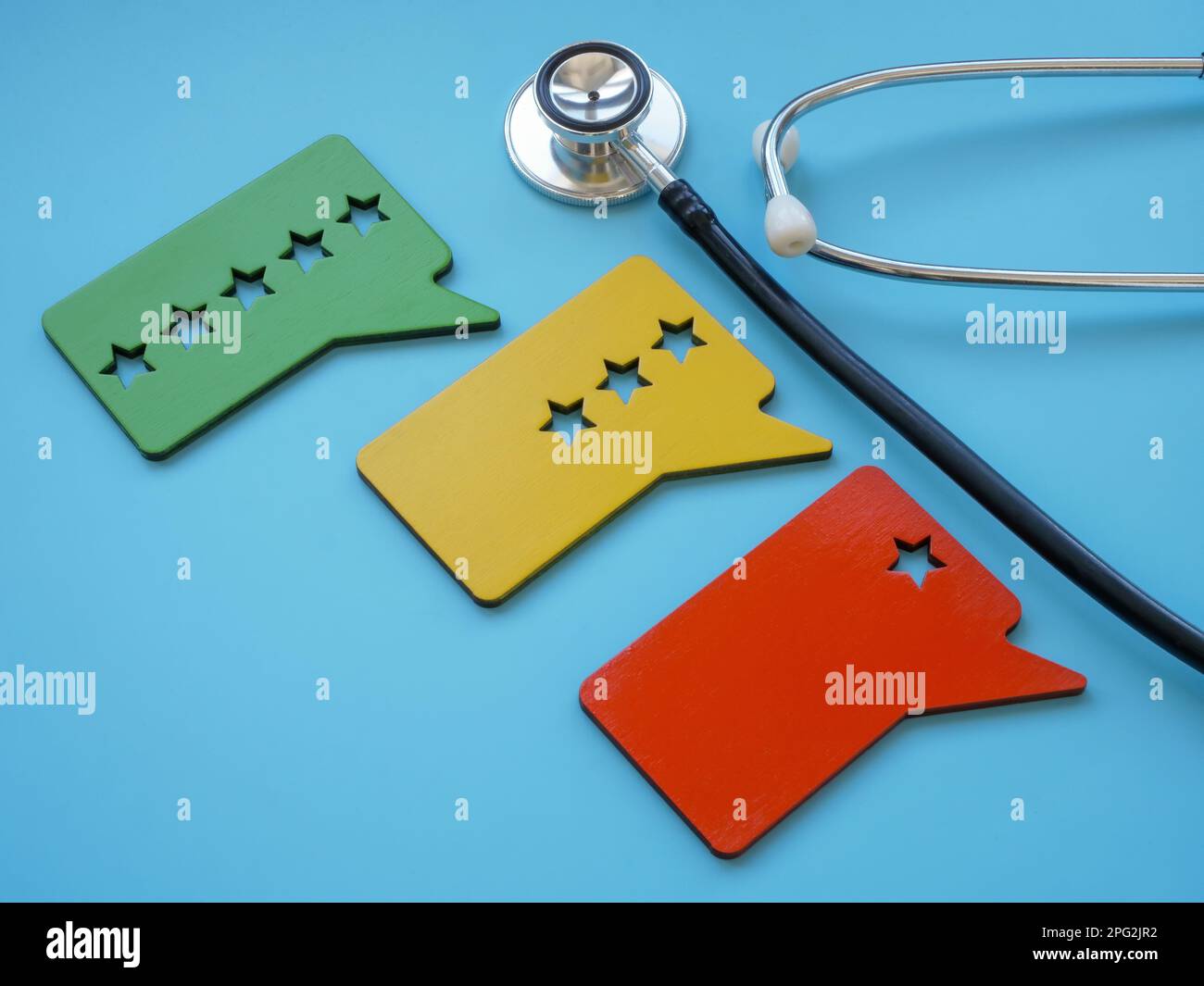 Stethoskop und mit Sternen versehene Platten als Symbol für die Beurteilung des Patientenerlebnisses. Stockfoto