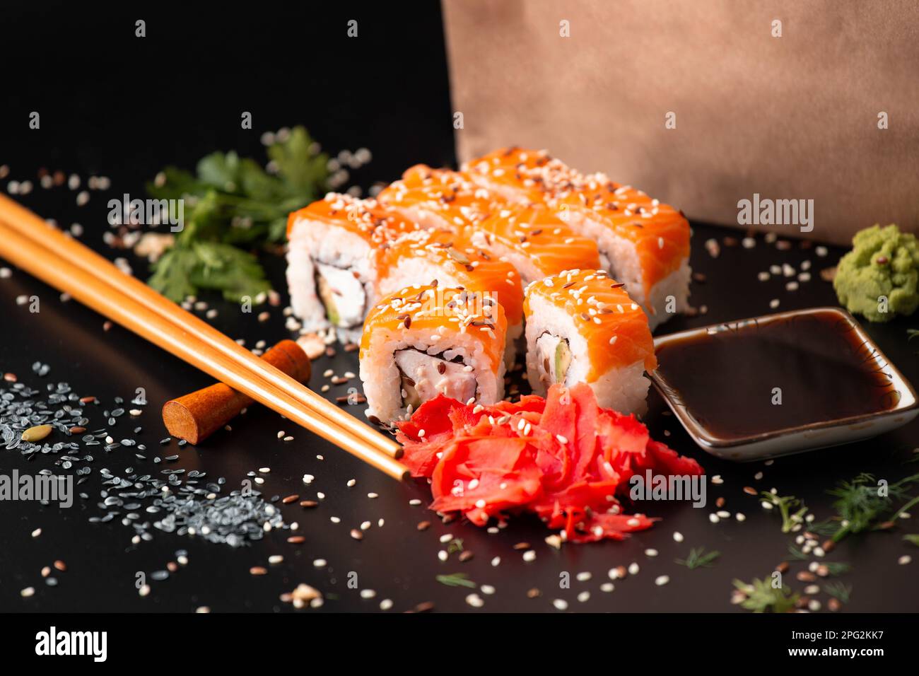 Die Auswahl verschiedener japanischer Sushi- und Brötchensorten. Auf dunklem rustikalem Hintergrund. Rollt auf dunklem Hintergrund. Meeresfrüchte mit Stäbchen. Stockfoto