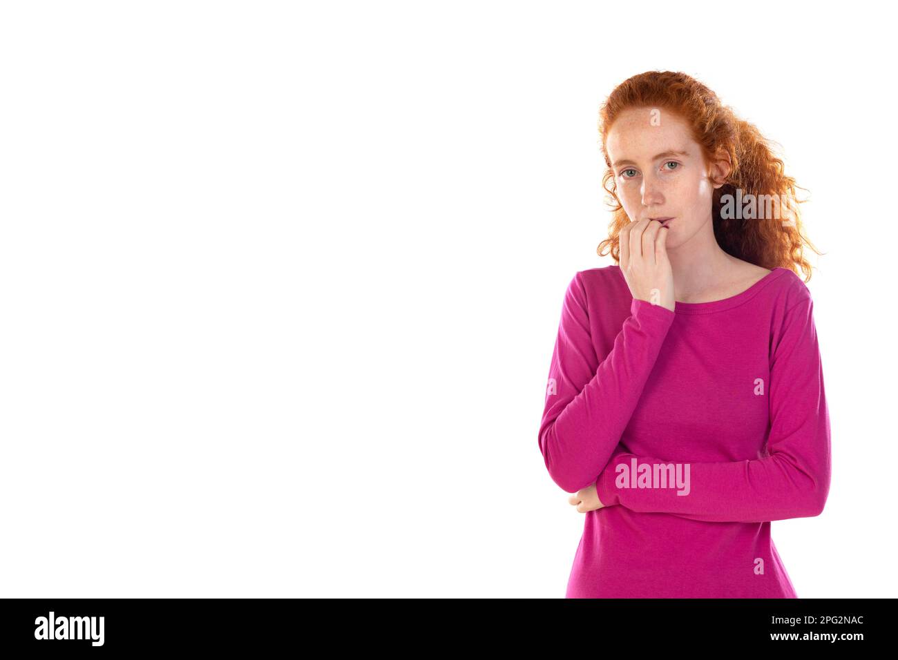 Foto einer nachdenklichen entzückten Frau, stellt sich etwas vor, hat welliges Ingwer-Naturhaar, trägt lässiges pinkes T-Shirt, steht gegen weiße Studiowand, Co Stockfoto