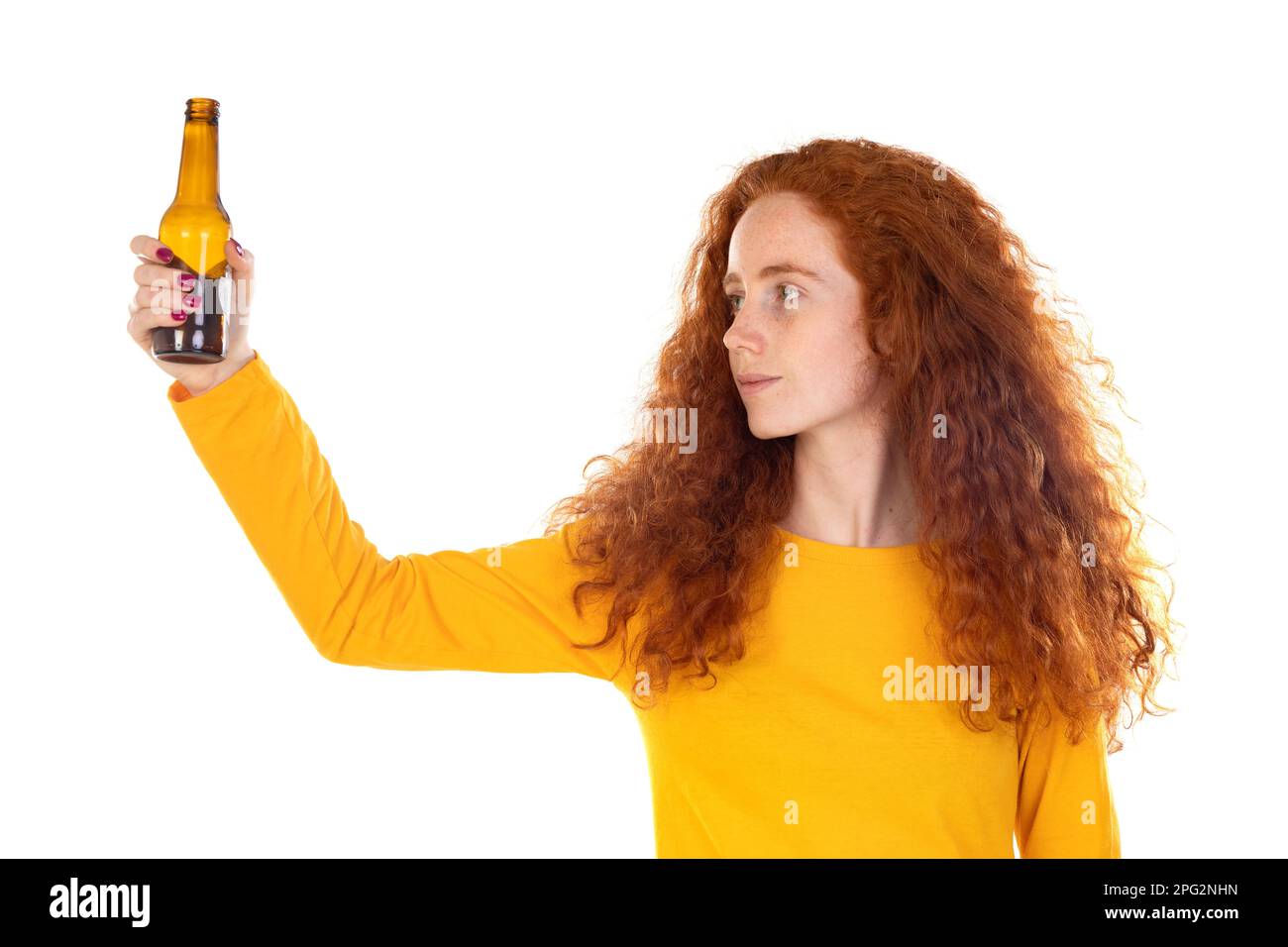 Junge rothaarige Frau an der weißen Wand, die eine Bierflasche hält, glücklich mit einem großen Lächeln Stockfoto