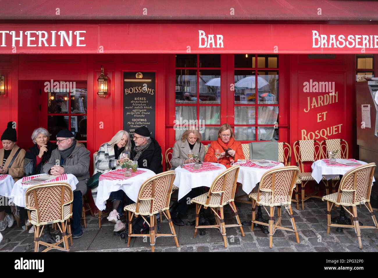 Touristen genießen ein Glas Wein auf dem Künstlerplatz Place du Tertre in Montmartre in Paris, Frankreich Stockfoto