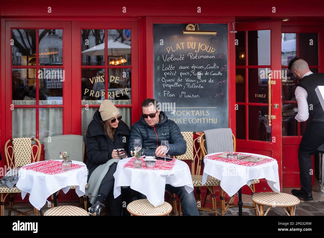 Touristen genießen ein Glas Wein auf dem Künstlerplatz Place du Tertre in Montmartre in Paris, Frankreich Stockfoto