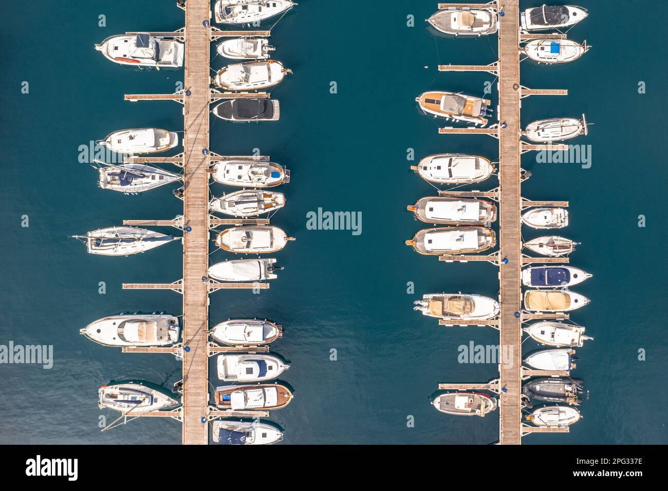 Yachten, Segel- und Motorboote in einem Hafen in Spanien. Uber das türkisblaue Wasser des Mediteranischen Meeres. Draufsicht von oben. Stockfoto