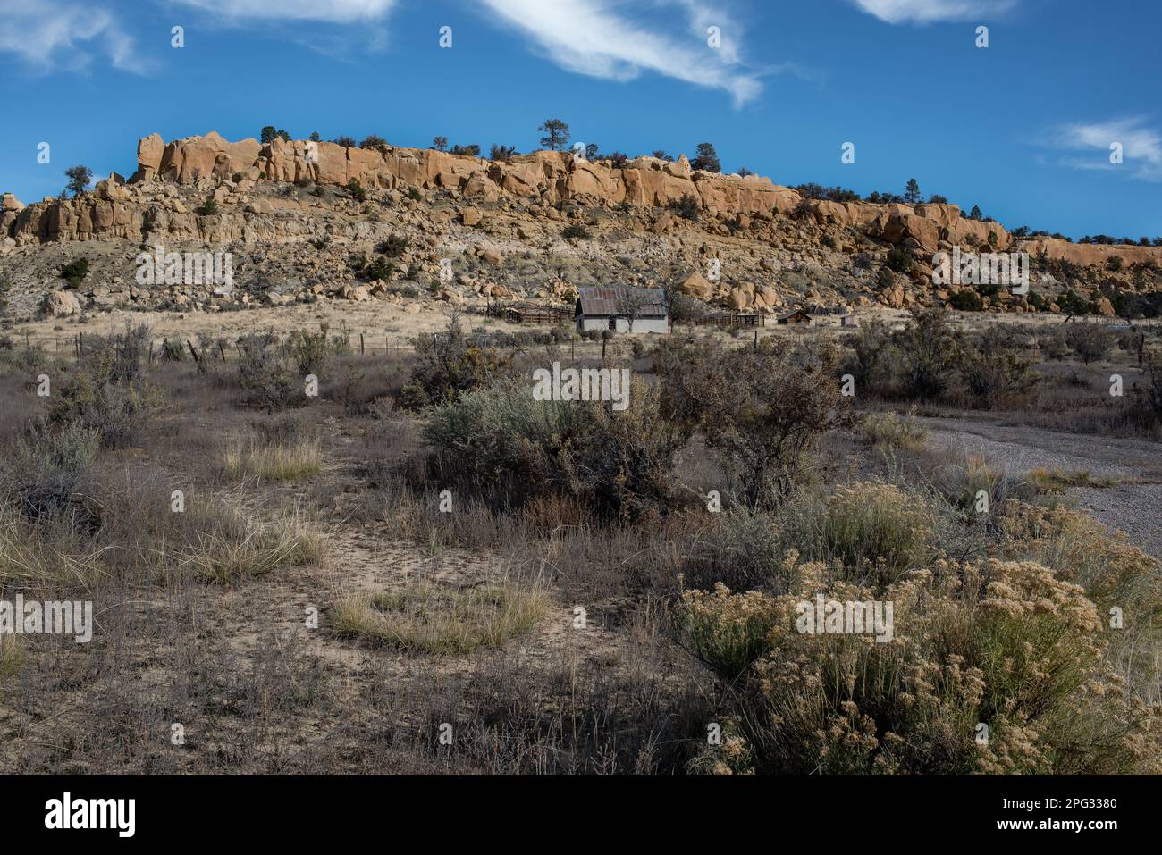 Trockene Landschaft im Rio Puerco Valley im Norden von New Mexico mit felsigen mesa und Ranch-Gebäuden. Stockfoto