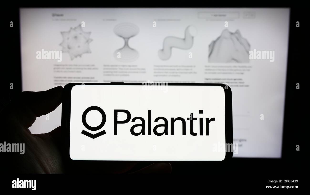 Person, die ein Mobiltelefon mit dem Logo des US-Analyseunternehmens Palantir Technologies Inc. Auf dem Bildschirm vor der Webseite hält. Konzentrieren Sie sich auf das Display des Telefons. Stockfoto