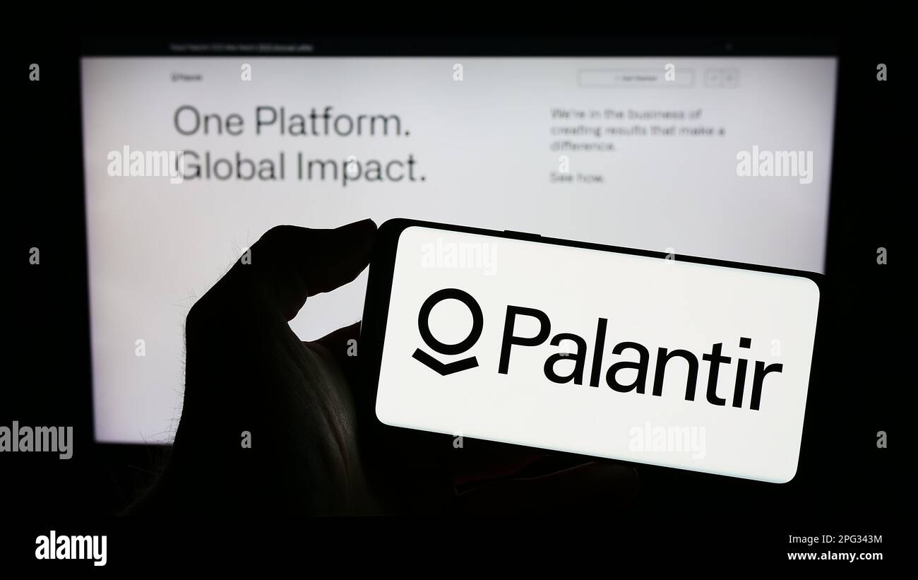 Person, die ein Mobiltelefon mit dem Logo des US-Analyseunternehmens Palantir Technologies Inc. Auf dem Bildschirm vor der Webseite hält. Konzentrieren Sie sich auf das Display des Telefons. Stockfoto