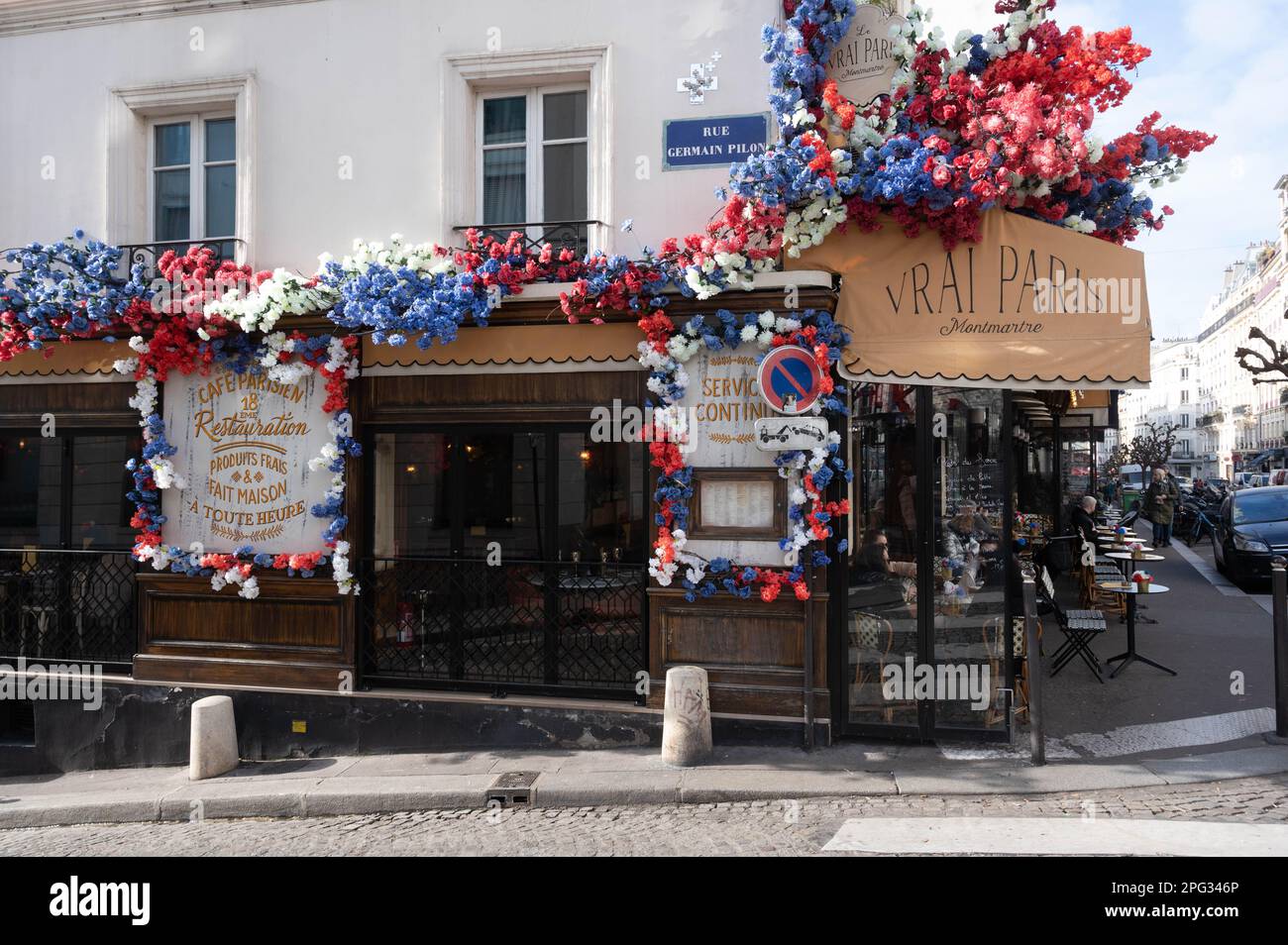 Le Vrai Paris, Bistro in der Rue des Abbesses, Montmartre, Paris, dekoriert mit Blumen der französischen Flagge Stockfoto