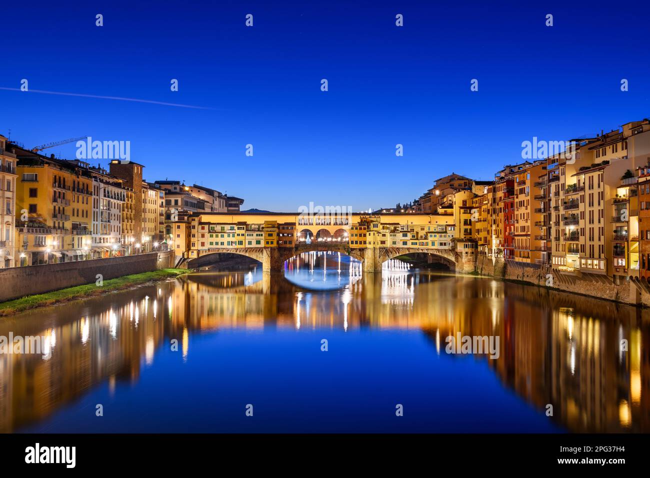 Florenz, Italien an der Brücke Ponte Vecchio, die in der Dämmerung den Arno überquert. Stockfoto