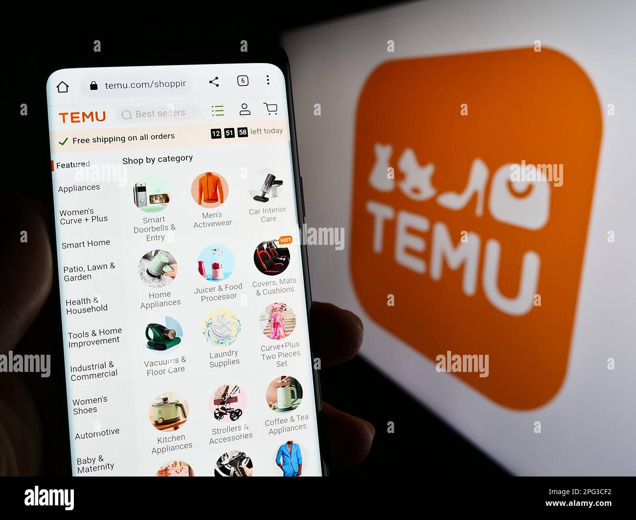 Person, die ein Mobiltelefon mit einer Webseite des amerikanischen Online-Shop-Unternehmens Temu auf dem Bildschirm vor dem Logo hält. Konzentrieren Sie sich auf die Mitte des Telefondisplays. Stockfoto