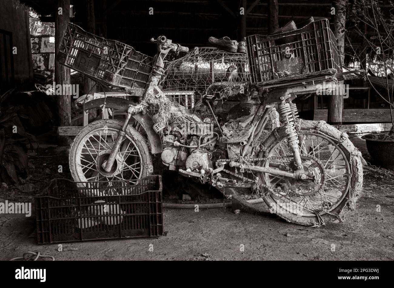 Ein verprügelter, verwüsteter und sehr schlammiger alter Motorradroller, der in einem Café in Dam Rong, Provinz Lam Dong, Vietnam, geparkt hat. Stockfoto