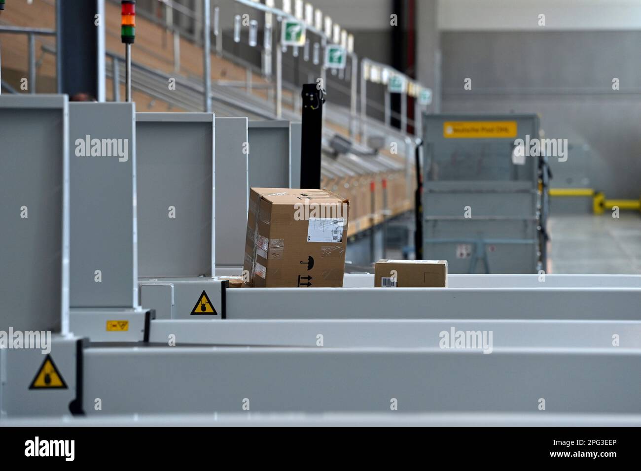 Deutsche Post DHL nimmt am 20. März 2023 den größten Paketstandort Deutschlands in Betrieb. Bearbeitung von bis zu 72.000 Paketen pro Stunde im Aschheim II-Paketzentrum bei München. Paket auf Förderband, Band. ? Stockfoto