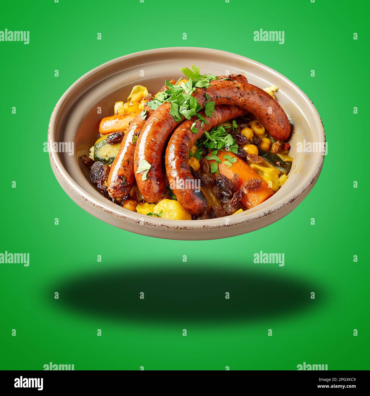 Schwimmender marokkanischer Merguez Couscous auf grünem Hintergrund Stockfoto