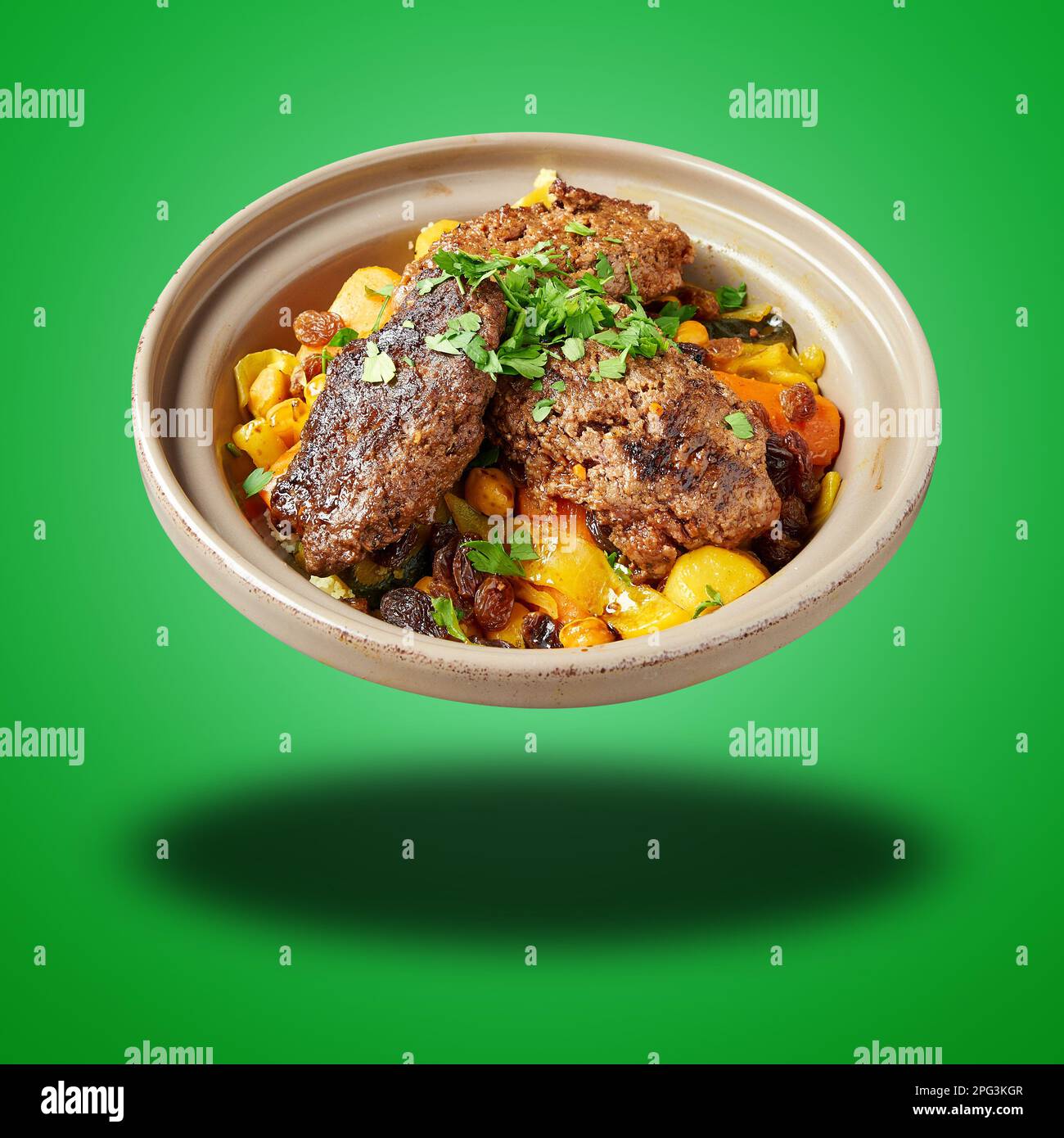 Schwimmender marokkanischer Kofte Couscous auf grünem Hintergrund Stockfoto