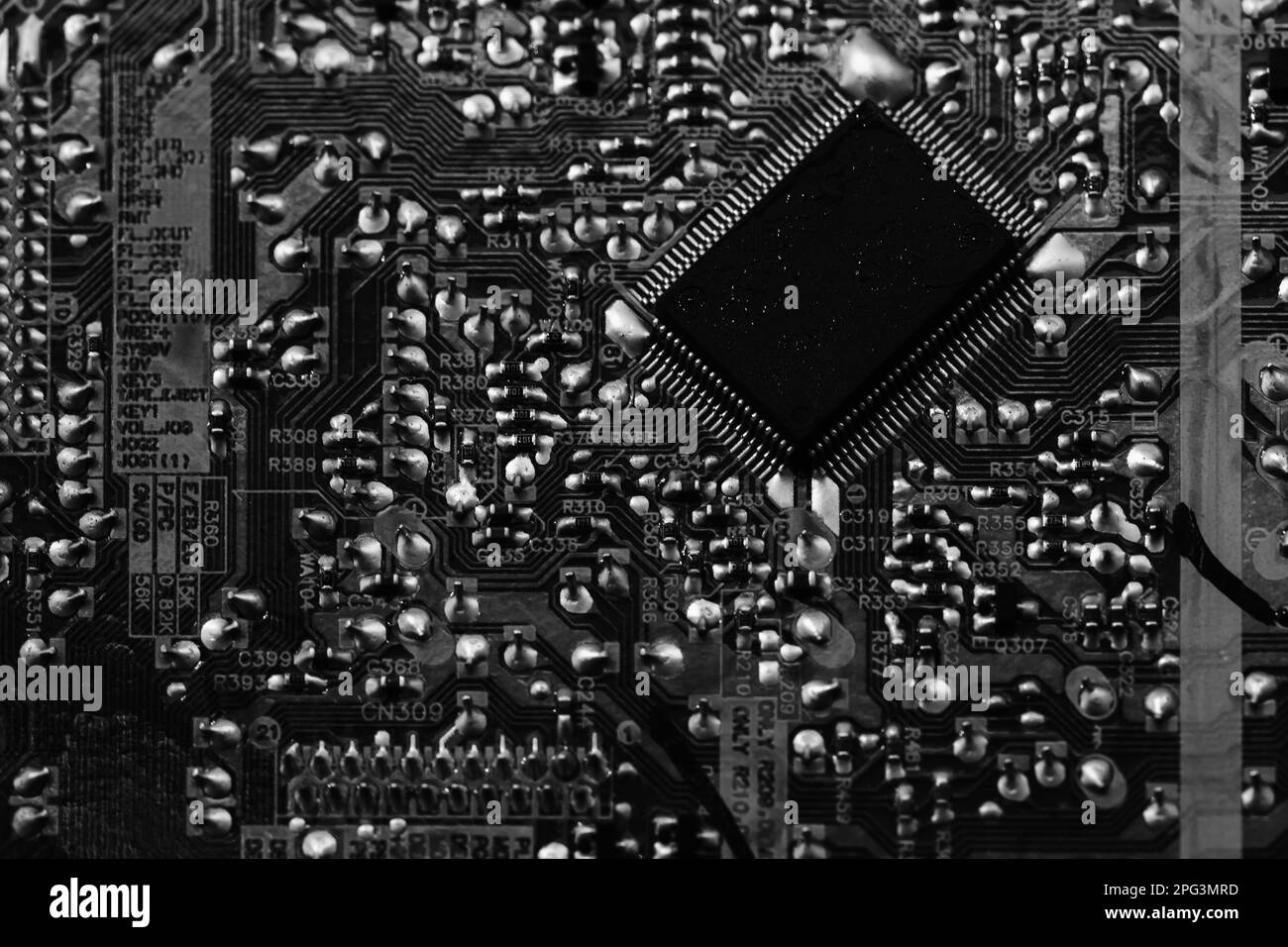 Draufsicht der Leiterplatte mit Mikrochip und Kondensatoren, Nahaufnahme Schwarzweißfoto Stockfoto
