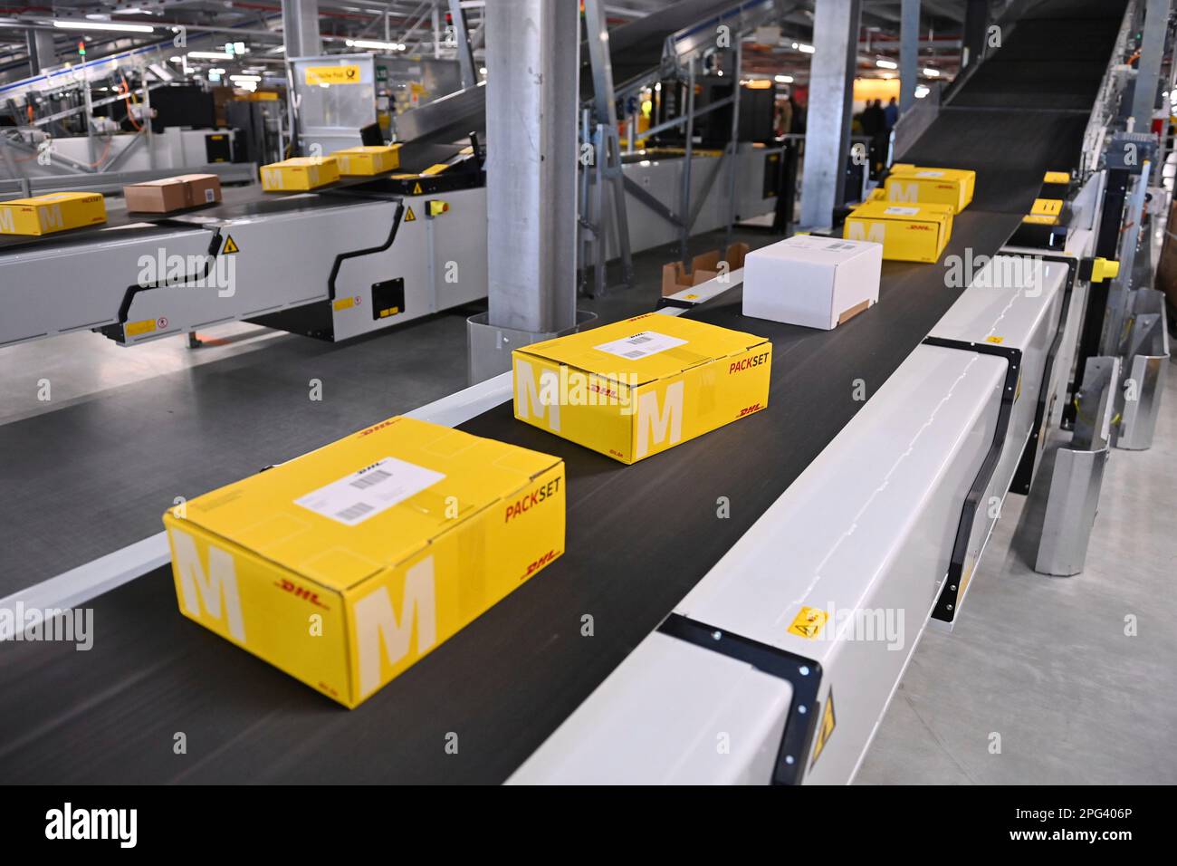 Deutsche Post DHL nimmt am 20. März 2023 den größten Paketstandort Deutschlands in Betrieb. Bearbeitung von bis zu 72.000 Paketen pro Stunde im Aschheim II-Paketzentrum bei München. Paket, Pakete auf Bändern, Förderband, Förderbänder? Stockfoto