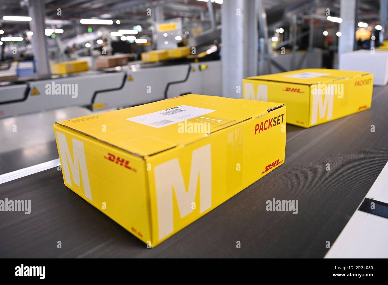 Deutsche Post DHL nimmt am 20. März 2023 den größten Paketstandort Deutschlands in Betrieb. Bearbeitung von bis zu 72.000 Paketen pro Stunde im Aschheim II-Paketzentrum bei München. Paket, Pakete auf Bändern, Förderband, Förderbänder? Stockfoto