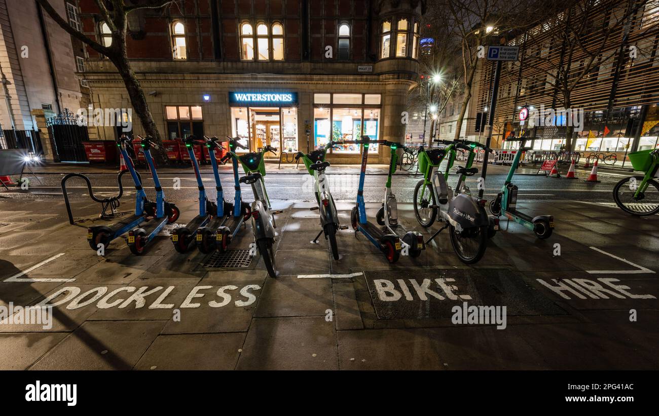 Elektrische Roller und docklose Leihfahrräder stehen in einer markierten Parkbucht in Schlange, um den Straßenlärm in Bloomsbury, im Zentrum von London, zu verringern. Stockfoto