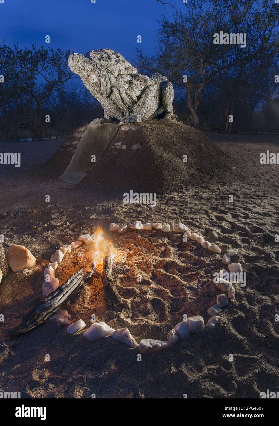 Felsskulptur des südafrikanischen Künstlers Andries Botha eines duckenden weißen Löwen vor einem Angriff. Das Werk ist 3,10 m lang und 1,35m m hoch und besteht aus Stockfoto