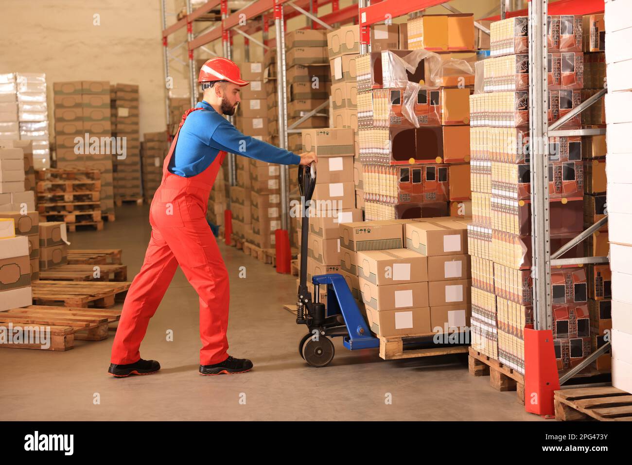 Arbeiter mit Palettenhubwagen im Lager. Logistikzentrum Stockfoto