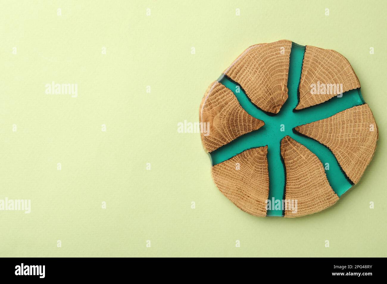 Stilvolle Untersetzer mit Holzbecher auf hellgrünem Hintergrund, Draufsicht. Platz für Text Stockfoto