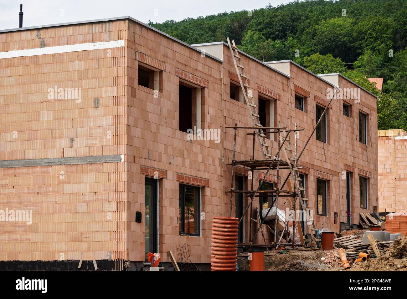 Kleine Baustelle, Wand aus orangefarbenen Ziegeln, kleine Gerüste in der Nähe Stockfoto