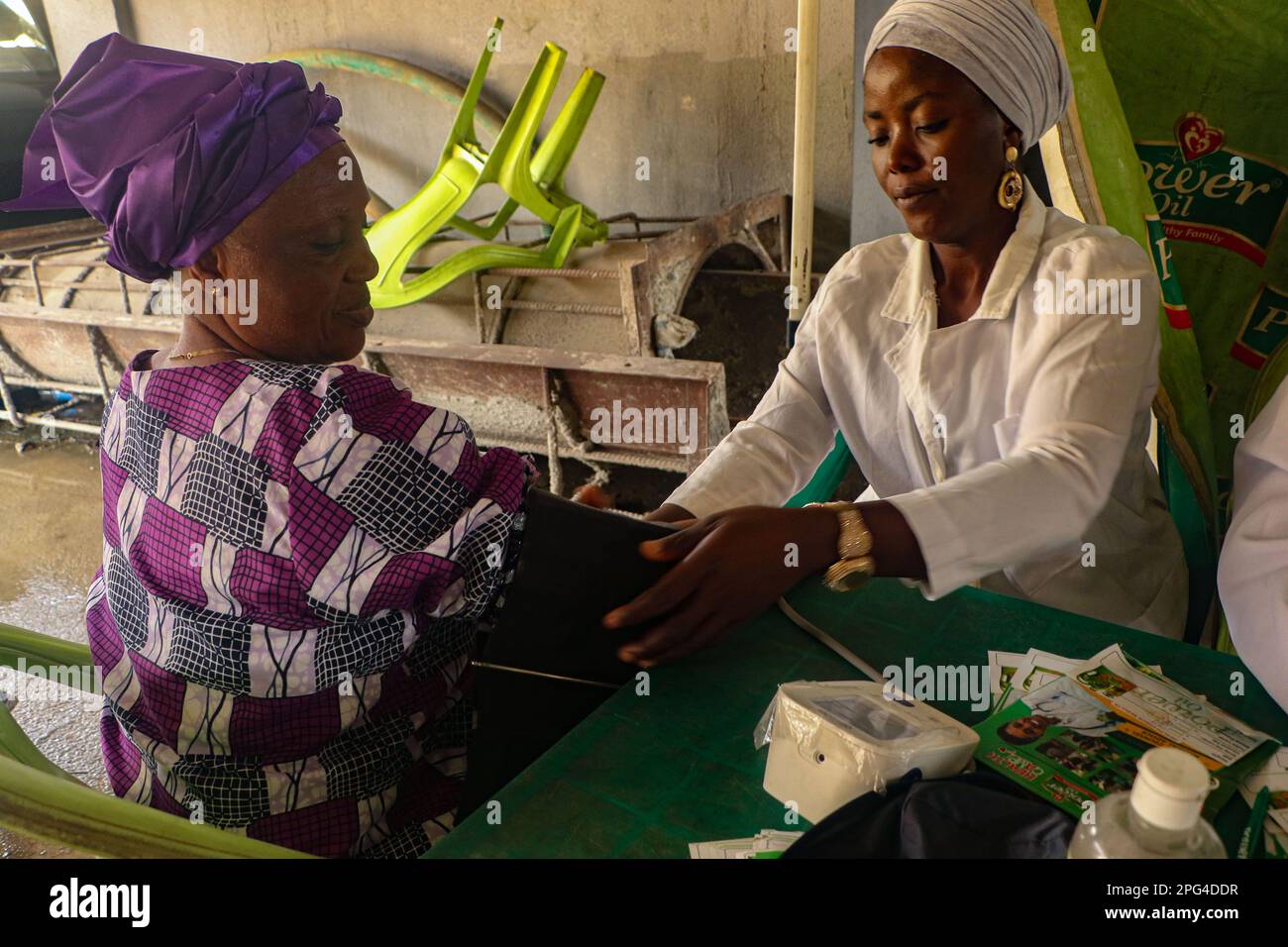 Medizinisches Personal betreut die Frau während einer kostenlosen medizinischen Untersuchung anlässlich des Internationalen Frauentags in der Mobolaji Johnson Arena in Lagos, Nigeria. Stockfoto
