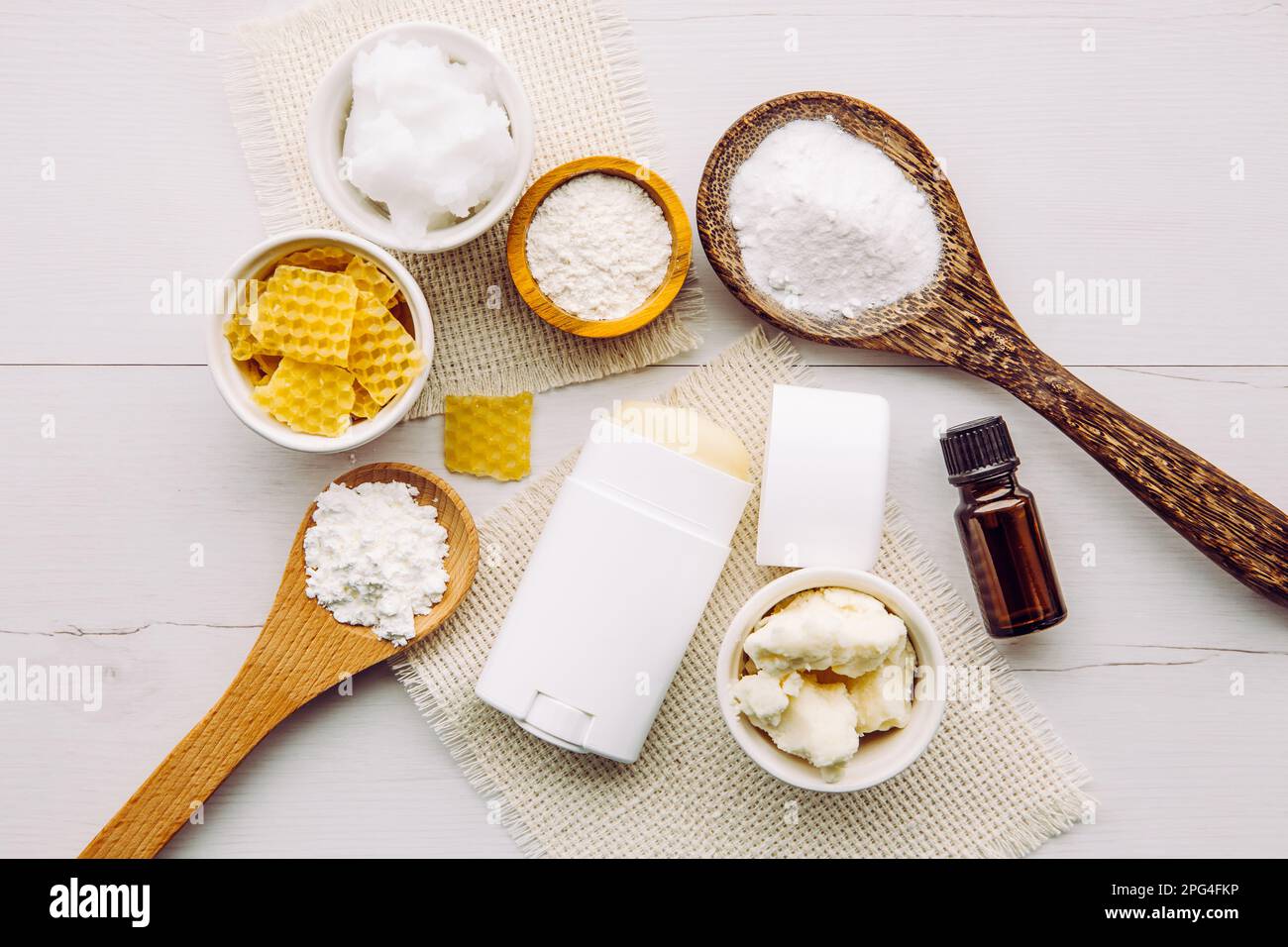 Konzept für die Herstellung von selbstgemachtem Deodorant mit allen natürlichen Inhaltsstoffen. Weißer Holzhintergrund. Zutaten: Pfeilwurzpulver, Backpulver, Bienenwachs. Stockfoto