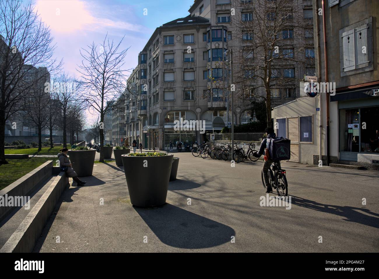 Unbekannte Person, die im Winter durch einen kleinen Park in Genf, Schweiz, fährt Stockfoto