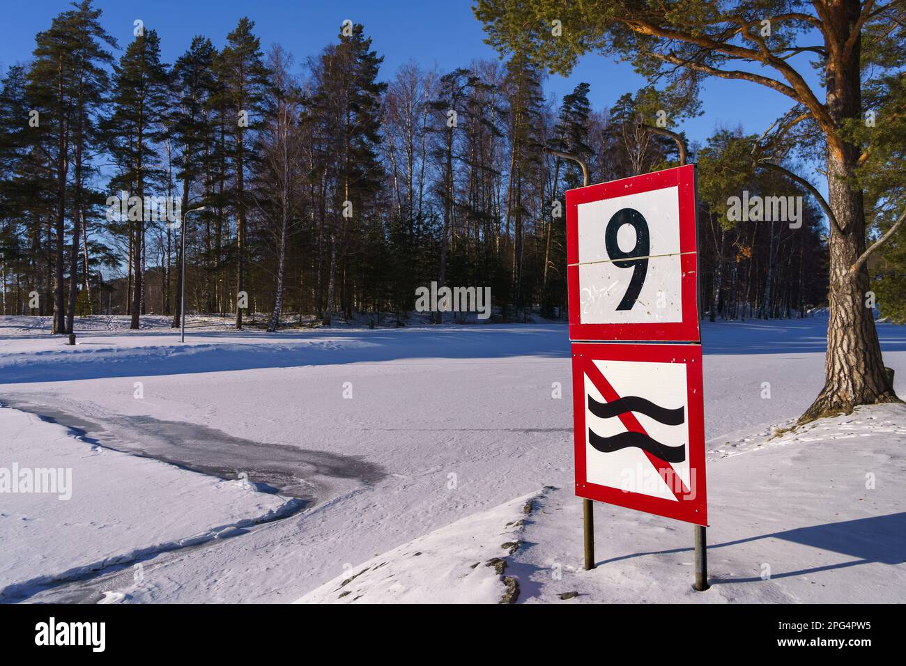 Schild Geschwindigkeitsbegrenzung und Verbot der Wellenbildung neben einem gefrorenen Fluss in Finnland. Stockfoto