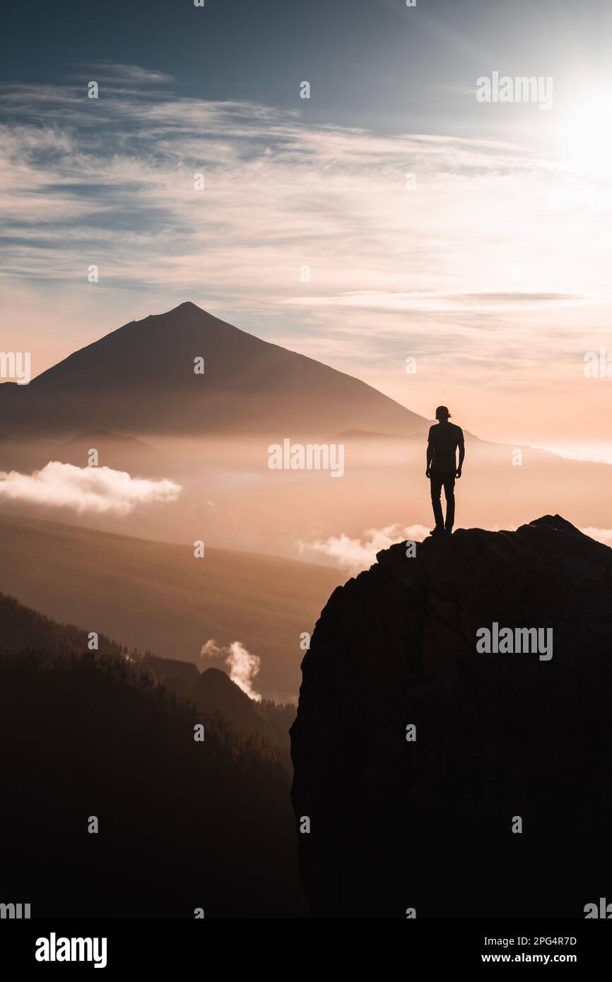 Una persona observando el pico Teide a contraluz al atardecer desde un mirador. En la isla de tenerife. Stockfoto