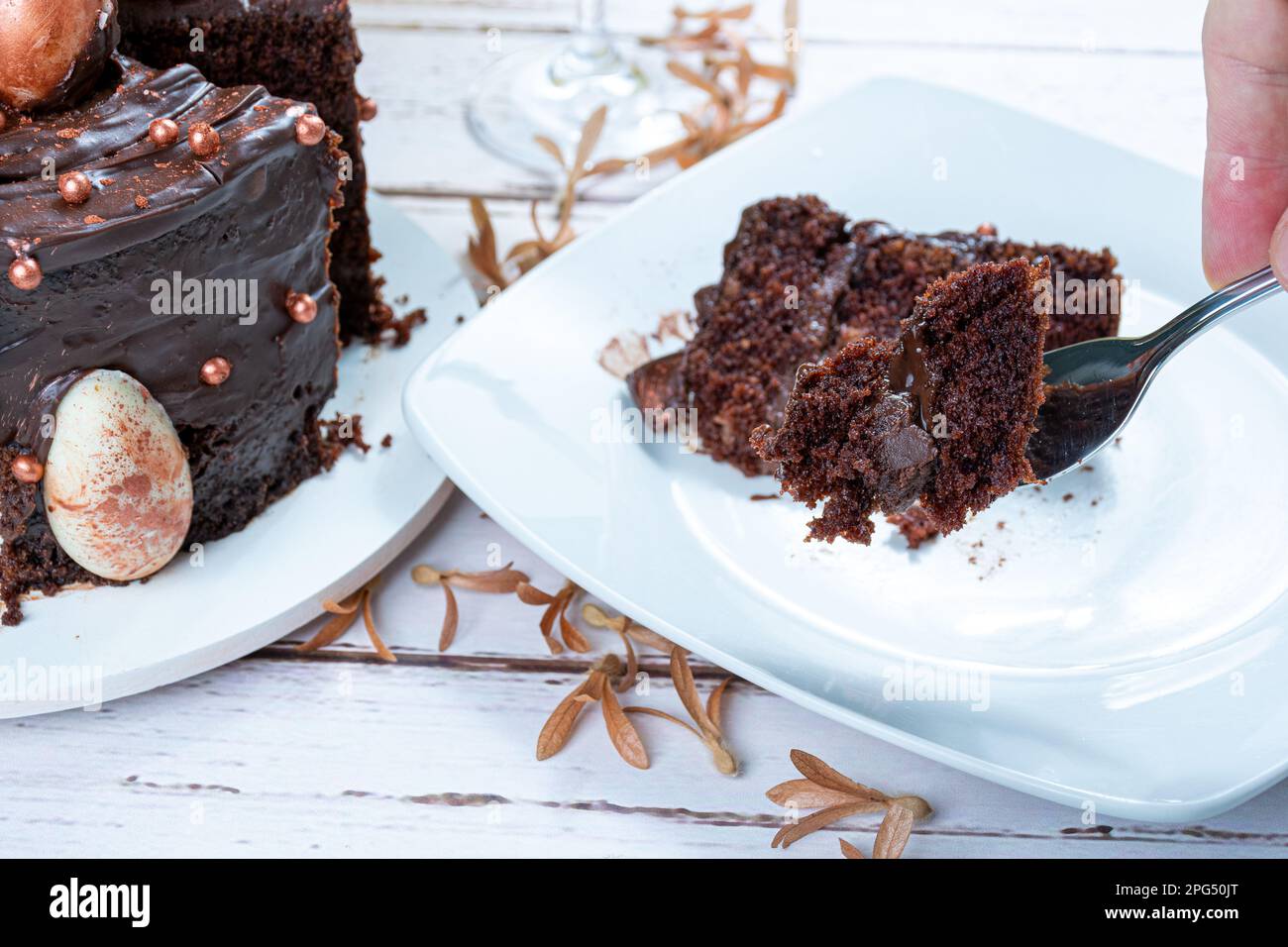 Männliche Hand hält ein Stück Schokoladenkuchen mit einer Gabel. Stockfoto