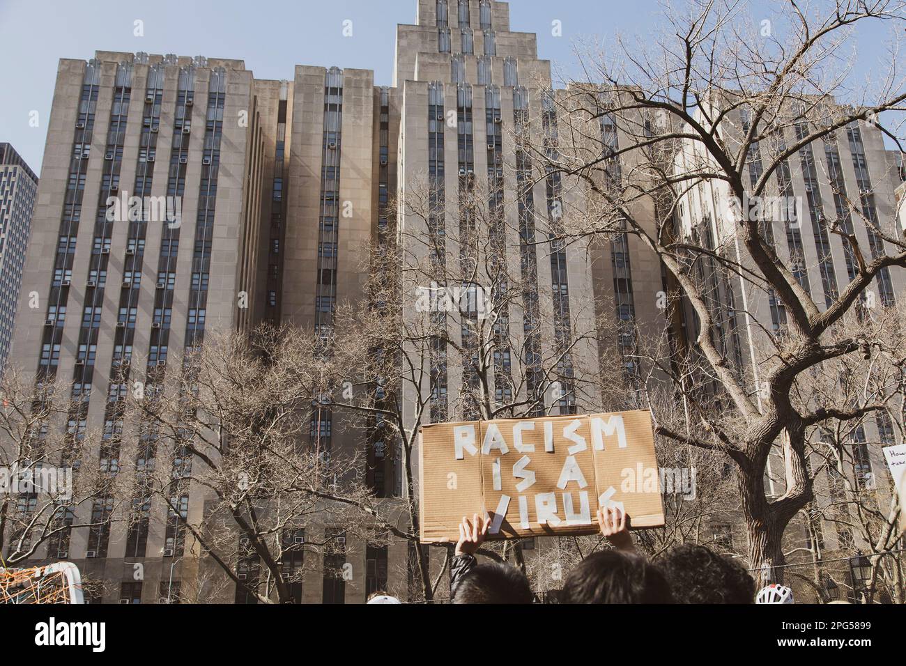 „Rassismus ist ein Virus“ Schild gegen Gebäude, Anti-asiatische Gewaltrundfahrt, New York City, New York, USA Stockfoto