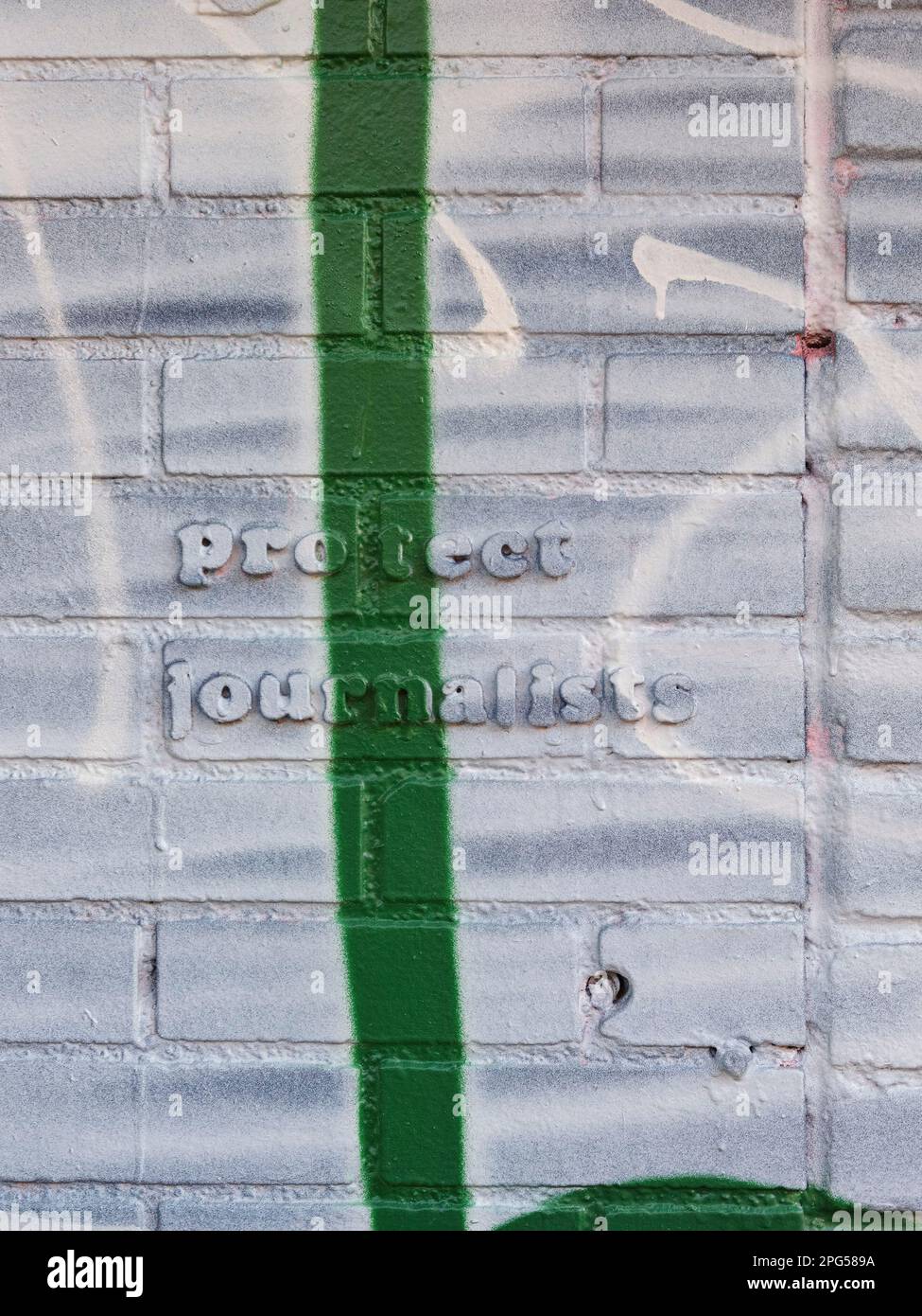 "Schützen Sie Journalisten' Zitat auf einer Mauer voller Farbe und Graffiti, New York City, New York, USA. Stockfoto