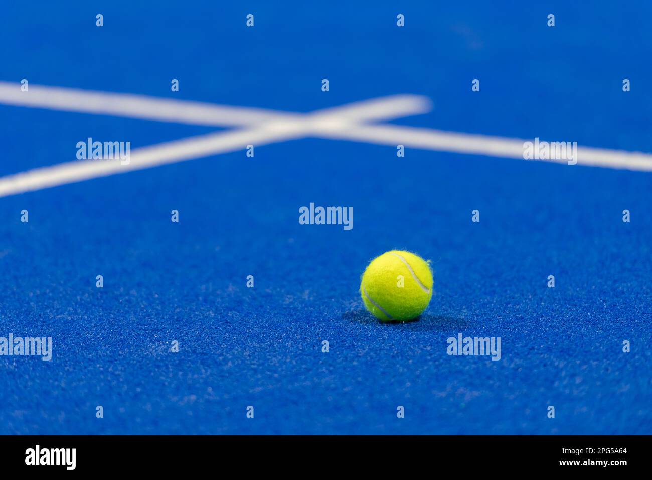 Gelber Tennisball auf dem Platz auf blauem Rasen. Horizontales Sportposter, Grußkarten, Kopfzeilen, Website Stockfoto