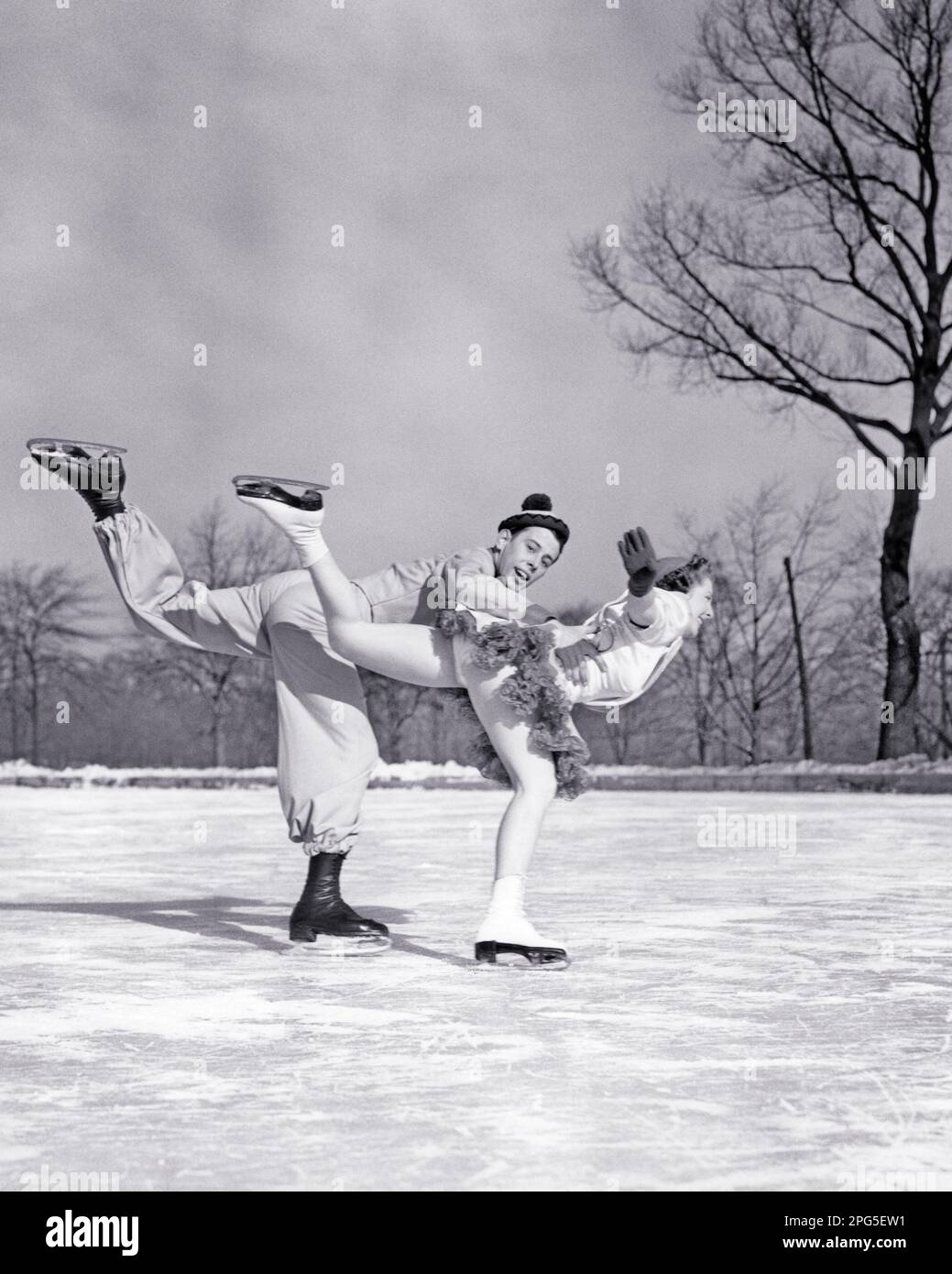 1930S 1940S PAAR MÄNNER UND FRAUEN PAAR EISKUNSTLÄUFER AUF DER EISLAUFBAHN IM FREIEN TRAGEN KOSTÜME MANN SCHAUT IN DIE KAMERA - W148 HAR001 HARS JUNGER ERWACHSENER BALANCE TEAMWORK WETTBEWERB SPORTLER KOSTÜME FREUDE AN LEBENSSTIL ZUFRIEDENHEIT FRAUEN ATHLETIK KOPIEREN WELTRAUMFREUNDSCHAFT DURCHGEHENDE DAMEN KÖRPERLICHE FITNESS PERSONEN INSPIRATION MÄNNER SPORTLICHE UNTERHALTUNG SCHWARZWEISS WINTERAKTIVITÄT KÖRPERLICHE ABENTEUER KRAFT UND AUFREGUNG NIEDERWINKELSPORTBESCHÄFTIGUNG STOLZ BERUFE PROFESSIONELLER SPORTLER FLEXIBILITÄT MUSKELN STILVOLLE UNTERSTÜTZUNG WINTERLICHE ZUSAMMENARBEIT PRÄZISIONSSKATER ZUSAMMENGEHÖRIGKEIT JUNGER ERWACHSENER MANN Stockfoto