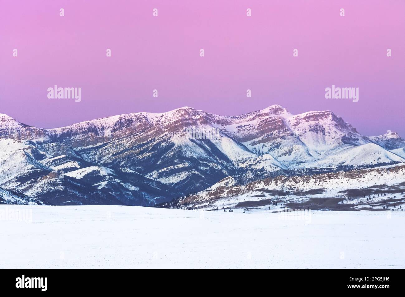 Im Winter bei augusta, montana, erstrahlt der Himmel vor Sonnenaufgang über dem Dampferberg an der felsigen Bergfront Stockfoto