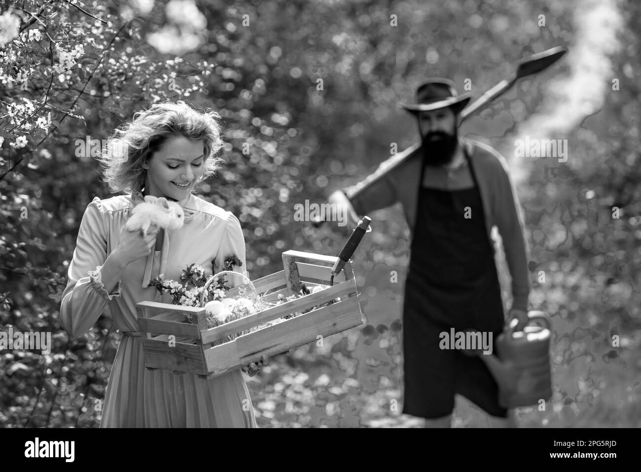 Zwei Personen im Garten im Hinterhof. Porträt eines jungen glücklichen Paares im Hof während der Frühjahrssaison. Landwirtschaft und Landwirtschaft Anbau. Stockfoto