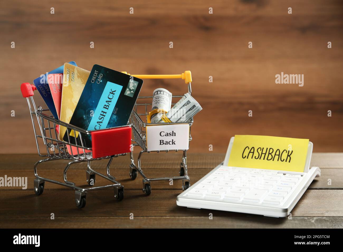 Komposition mit Schildern „Cash Back“, Kreditkarten und Taschenrechner auf Holztisch Stockfoto