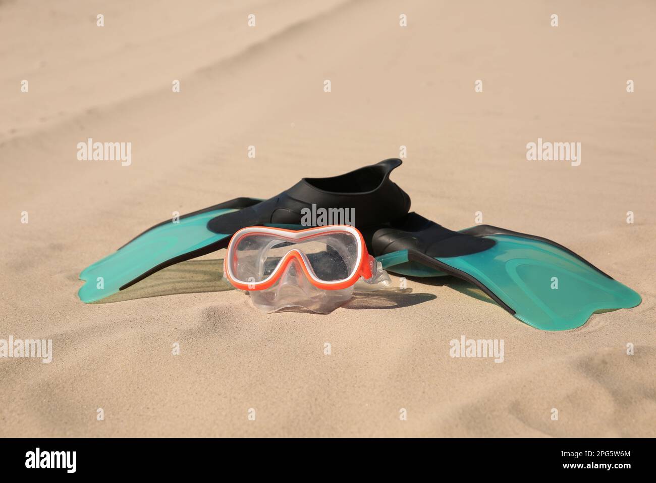 Ein Paar Flossen und eine Tauchermaske am Sandstrand Stockfoto