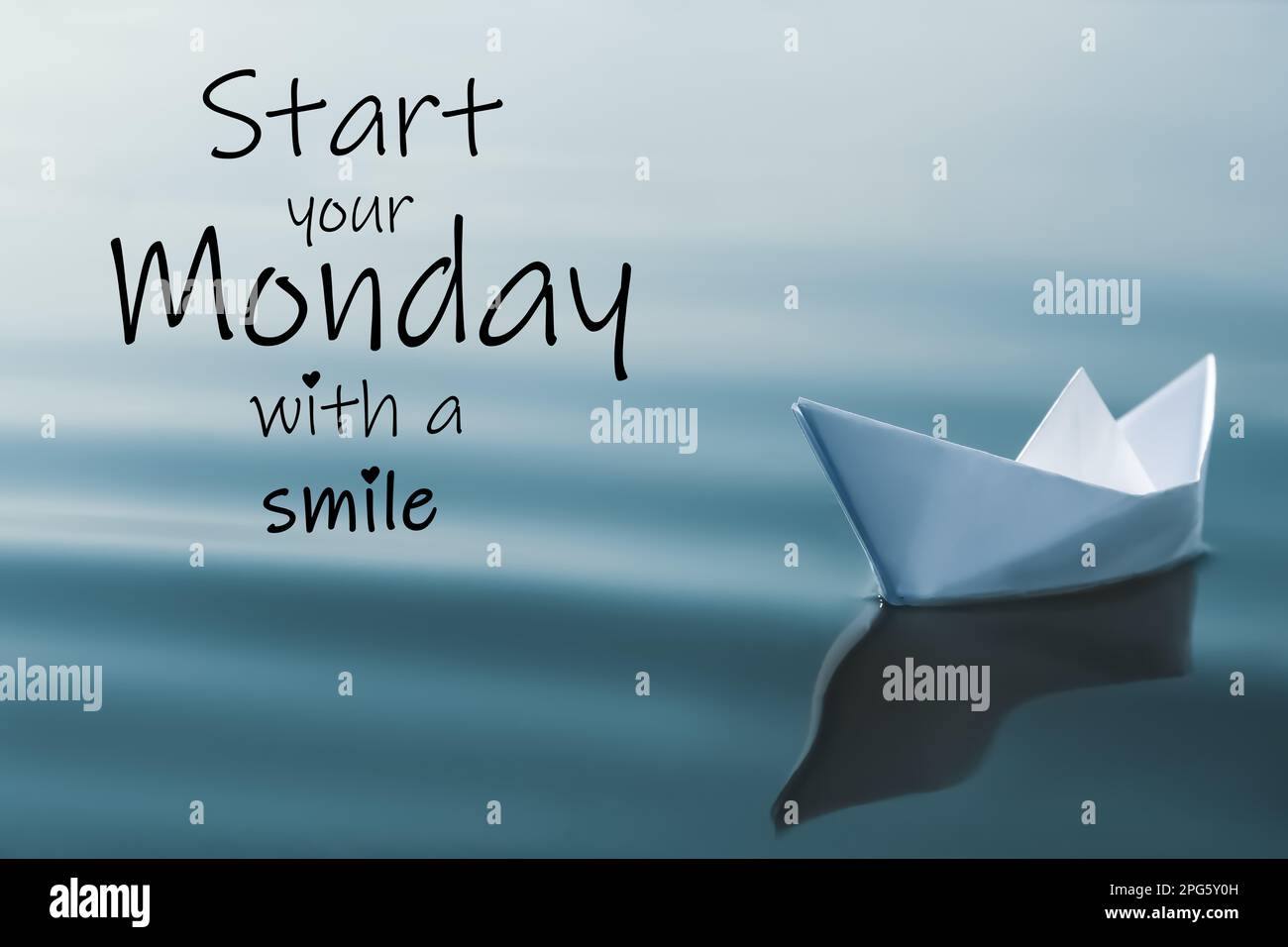 Motivierendes Zitat Beginnen Sie Ihren Montag mit einem Lächeln und einem weißen Papierboot auf dem Fluss Stockfoto
