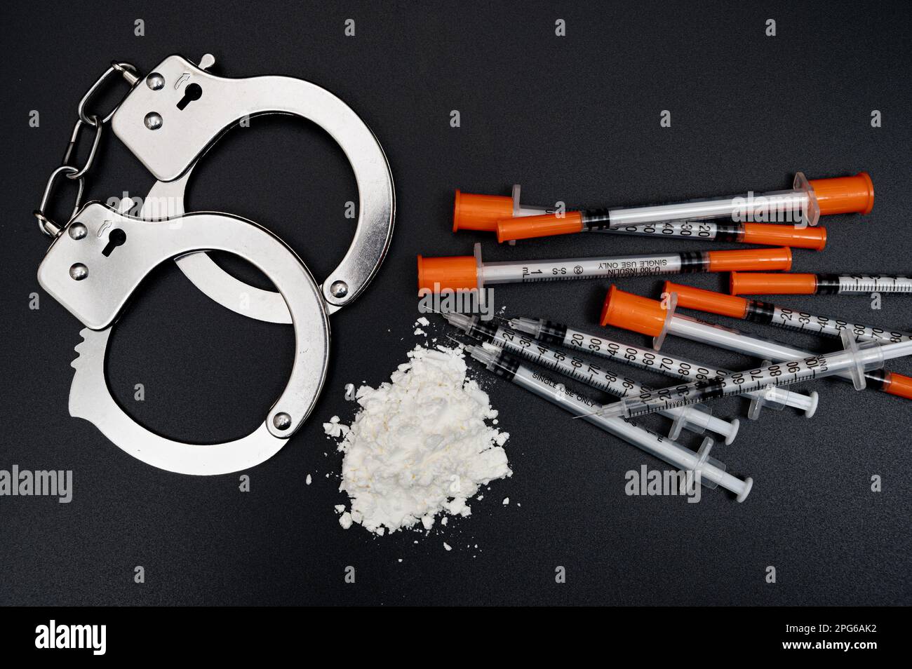 Drogenkriminalitätskonzept mit weißem Pulver und Einwegspritze auf schwarzem Hintergrund Stockfoto